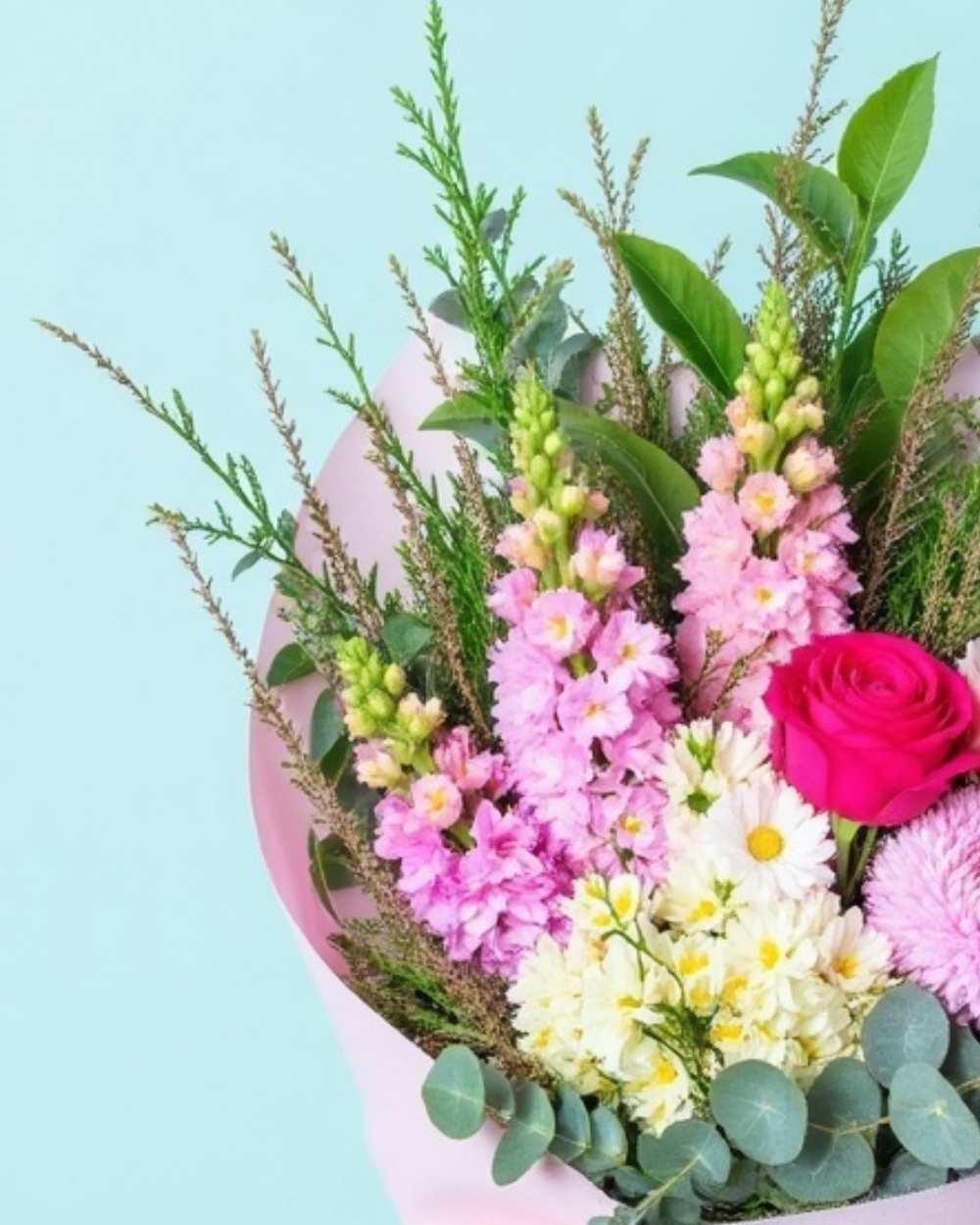 Closeup of the Happy Birthday bouquet featuring pink flowers and greenery.