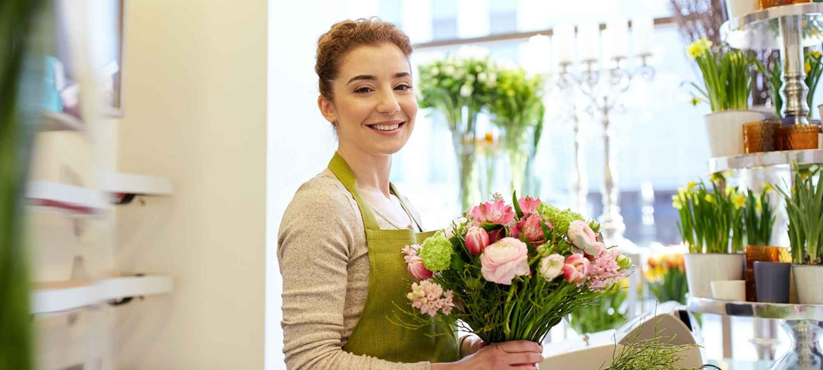 florist holding a bouquet of flowers for delivery to Auckland.